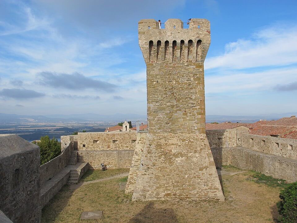 Torre medievale a Piombino che si erge su mura antiche con vista panoramica.