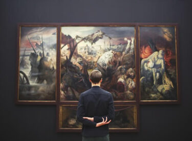 Uomo di spalle che osserva un grande dipinto diviso in pannelli, in un museo d'arte.