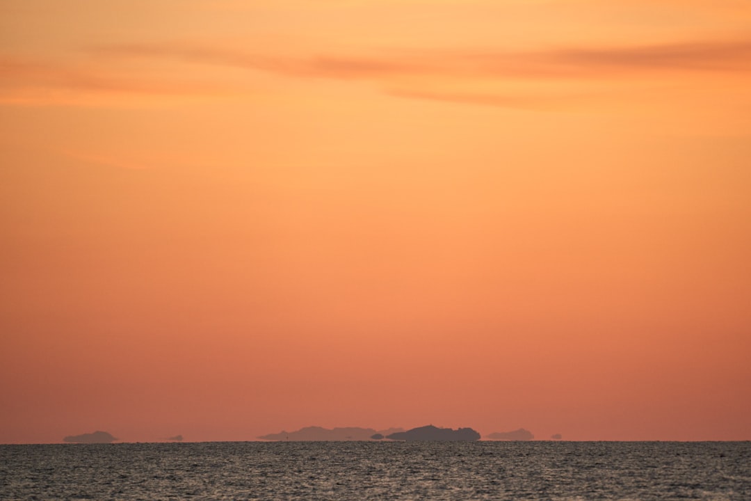 Tramonto sul mare con cielo arancione e sagome di isole all'orizzonte Isola di Capraia